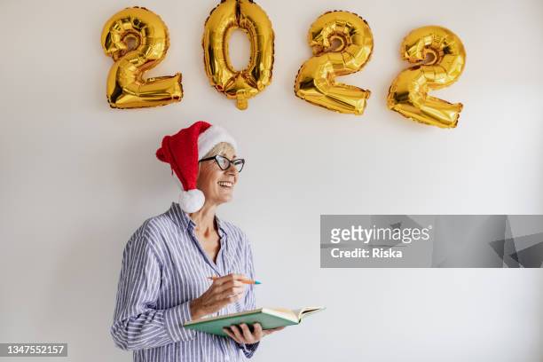 studio shot of senior woman celebrating new year 2022 - 2022 a funny thing stock pictures, royalty-free photos & images