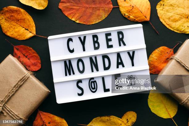 cyber monday symbol. lightbox with text cyber monday, gift boxes, autumn yellow leaves. - cyber monday stock pictures, royalty-free photos & images