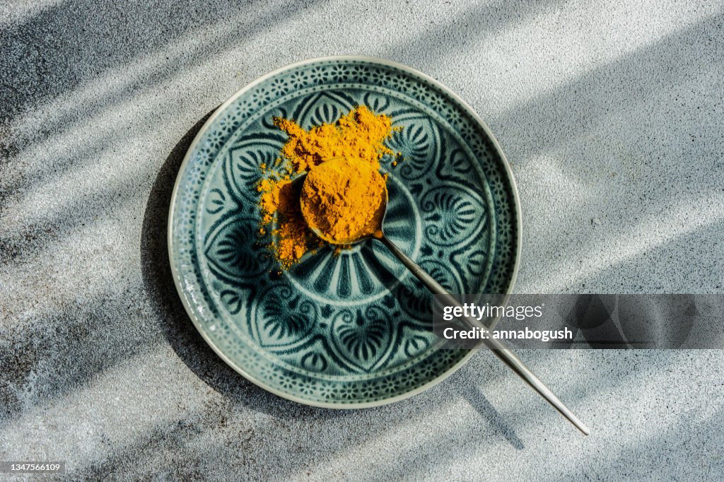 Spoonful of turmeric powder on a plate