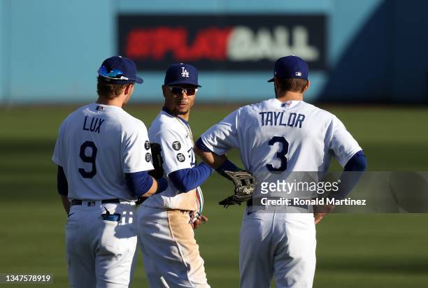 Gavin Lux, Mookie Betts, and Chris Taylor of the Los Angeles Dodgers talk during a pitching change in the 6th inning of Game 3 of the National League...