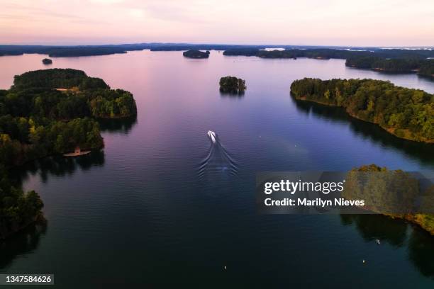 boat is out on lake lanier at sunset - georgia stock pictures, royalty-free photos & images