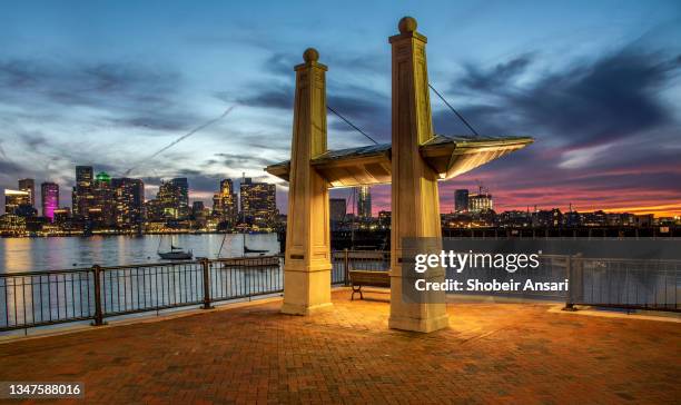 beautiful sunset at boston harbor with skyline in background, boston, massachusetts - boston beacon hill stock-fotos und bilder