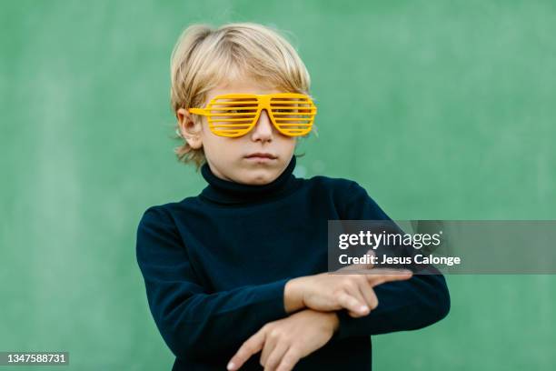 caucasian boy, with yellow party glasses, with a rapper's pose. with a street wall in the background. children, psychology, music and education concept. - baby rapper ストックフォトと画像
