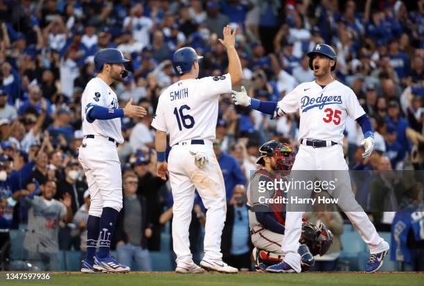 Cody Bellinger of the Los Angeles Dodgers is congratulated by Will Smith and AJ Pollock after hitting a 3-run home runduring the 8th inning of Game 3...