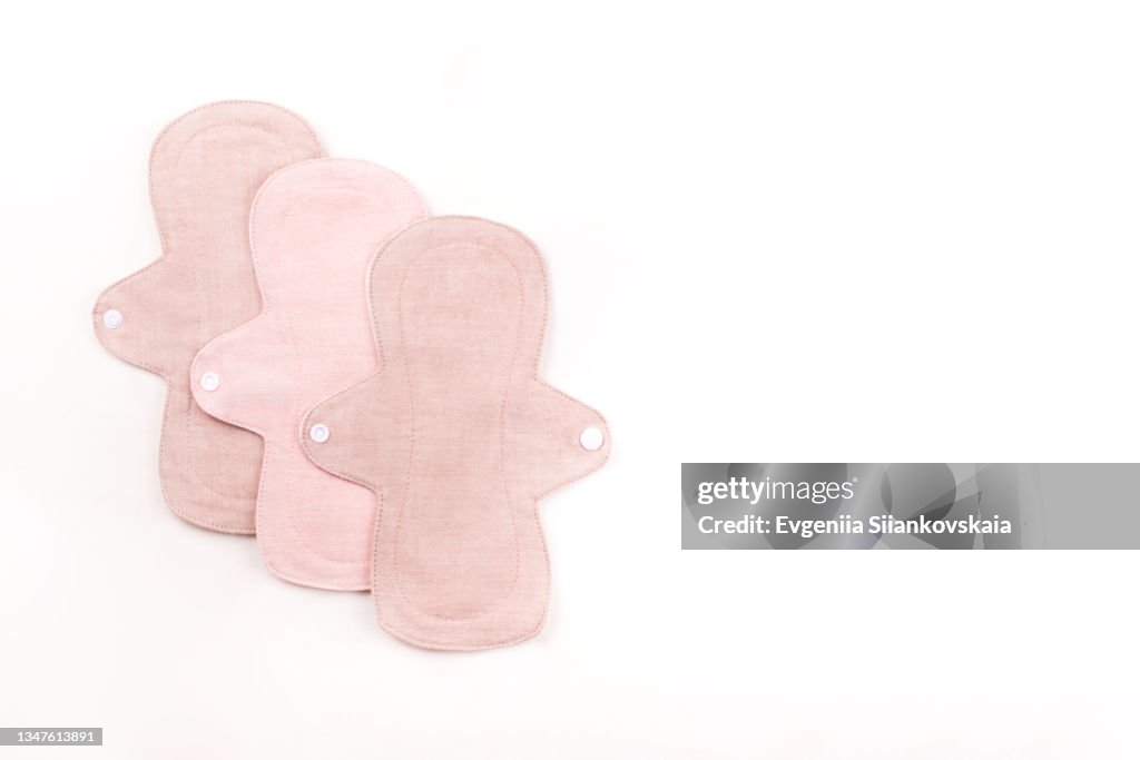 Reusable cloth menstrual pads on white background.