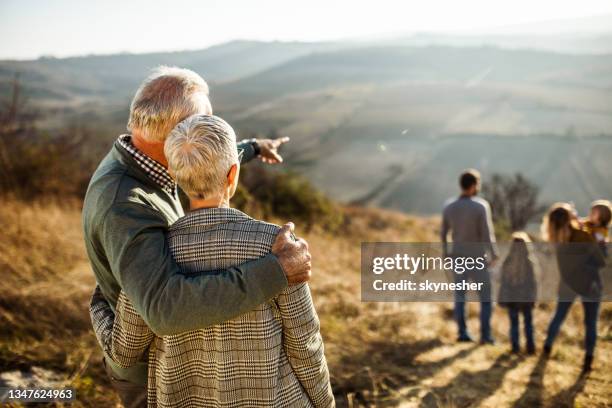 back view of embraced grandparents in autumn day on a field. - multi generation family from behind stock pictures, royalty-free photos & images