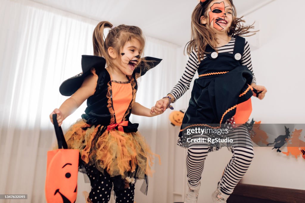 Dos Hermanas Emocionadas Vestidas Con Disfraces De Halloween Saltando Sobre  La Cama Foto de stock - Getty Images