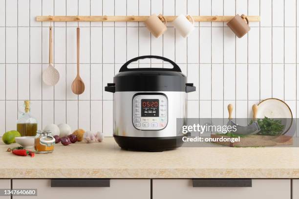 multi cooker on kitchen counter with onions, garlic, cooking oil and cutting board - vegetables white background stock pictures, royalty-free photos & images