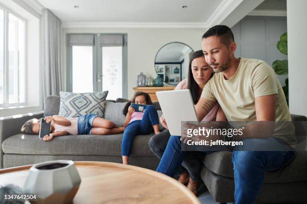 shot of a young couple using a digital tablet at home - couple with ipad in home stock pictures, royalty-free photos & images