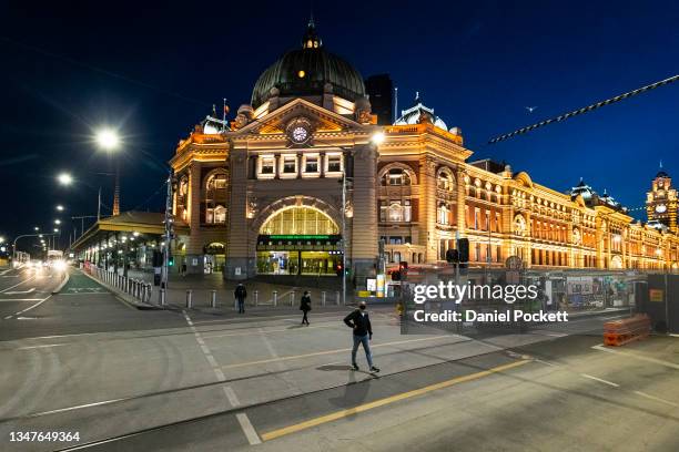 People walk across Flinders Street on October 20, 2021 in Melbourne, Australia. Lockdown restrictions will lift in Melbourne from Friday 22 October,...