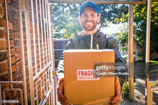 cropped portrait of a handsome young male courier making a door to door delivery - fragile sign stock pictures, royalty-free photos & images