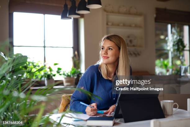 happy young woman writing and studying at home. - huiswerk stockfoto's en -beelden