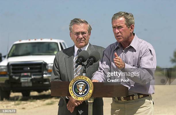 President George W. Bush speaks during a press conference as U.S. Secretary of Defense Donald Rumsfeld stands next to him, after a morning defense...