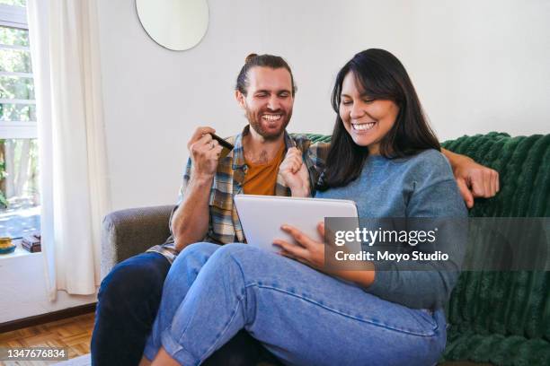 shot of a young couple using their digital tablet to make online payments - debt free stock pictures, royalty-free photos & images