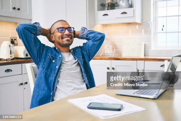 foto de un joven tomando un descanso mientras trabajaba en casa - preocupación financiera fotografías e imágenes de stock