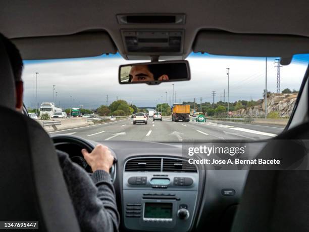 car point of view, young man driving a car on a two-lane highway with a lot of traffic - car point of view stock pictures, royalty-free photos & images