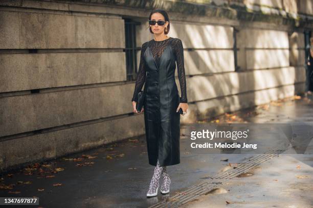 Influencer and Oha Kidswear founder Alexandra Guerain wears black sunglasses, a Fendi logo sheer top under a black leather sleeveless dress, black...