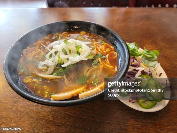 high angle view of food in bowl on table - pho soup stock-fotos und bilder