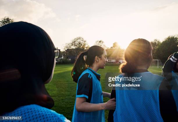 cropped shot of a group of athletic young female footballers training outside on the soccer pitch - sports bib stock pictures, royalty-free photos & images