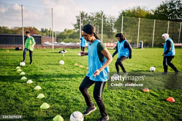 cropped shot of an athletic young female footballer training on the pitch with her teammates in the background - sports training drill bildbanksfoton och bilder