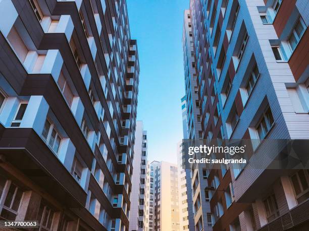 low angle view of residential buildings against blue sky - apartment foto e immagini stock