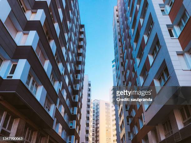 low angle view of residential buildings against blue sky - 公寓 個照片及圖片檔