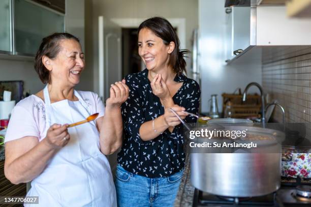 elderly woman and her daughter are cooking ashura in the kitchen for the whole family and tasting it - festividade religiosa islâmica ashura imagens e fotografias de stock