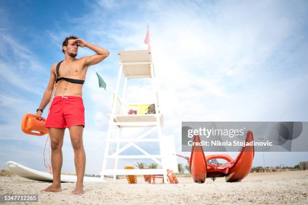 rettungsschwimmer bereitet die boje vor - bademeister stock-fotos und bilder
