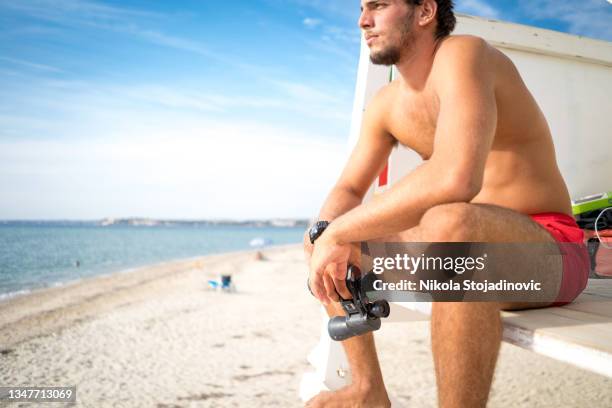 lifeguard on duty looking with binoculars - beach lifeguard stock pictures, royalty-free photos & images