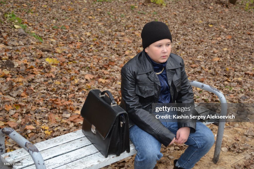 A teenage boy wearing a black leather jacket.