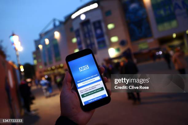 Detailed view of the NHS App on a fans phone as they arrive at the stadium prior to the UEFA Champions League group H match between Chelsea FC and...