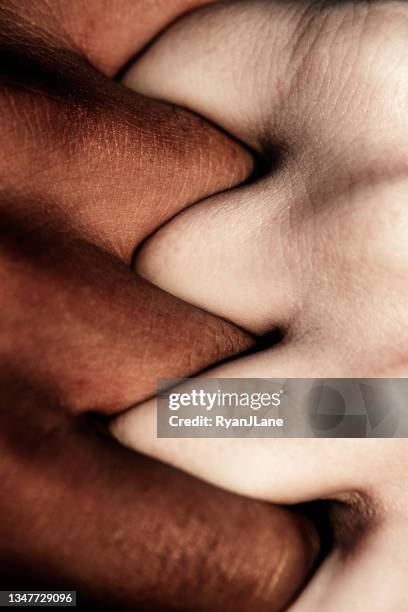 kontrastierende hautfarbe händchenhalten - black and white holding hands stock-fotos und bilder
