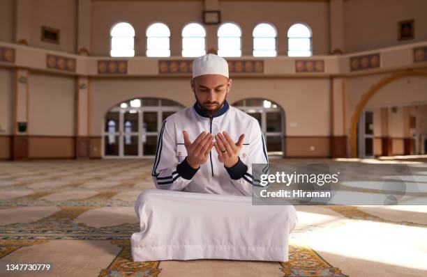 shot of a young muslim man holding up his hands while praying in a mosque - handsome muslim men stock pictures, royalty-free photos & images