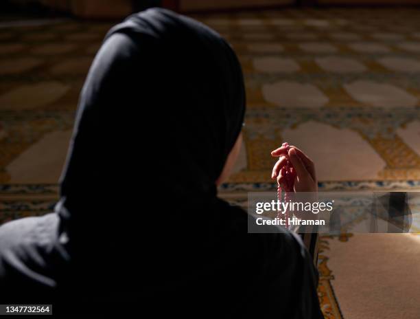 rearview shot of a muslim woman holding prayer beads in a mosque - namaz stock pictures, royalty-free photos & images