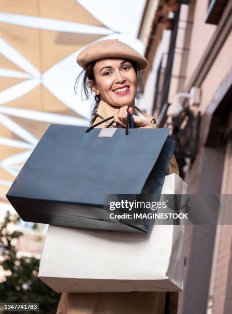 young woman with shopping bags walking on city street - budding starlets stock pictures, royalty-free photos & images