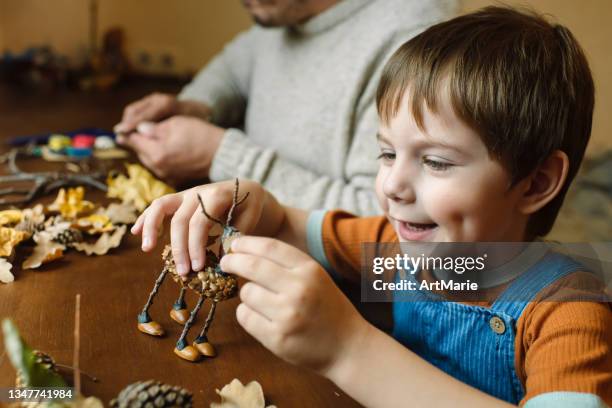 little boy and his father making handcrafts at home in autumn - autumn indoors stock pictures, royalty-free photos & images