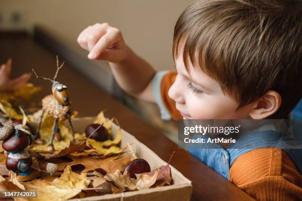 little boy and his father making handcrafts at home in autumn - live oak stock pictures, royalty-free photos & images