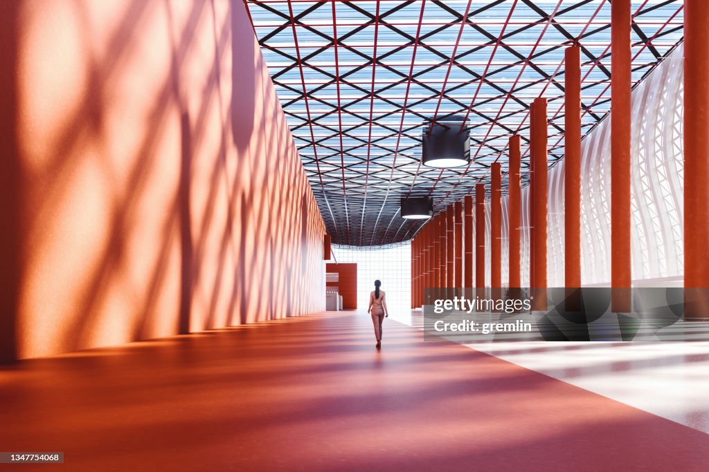 Lone businesswoman walking in empty exhibition hall