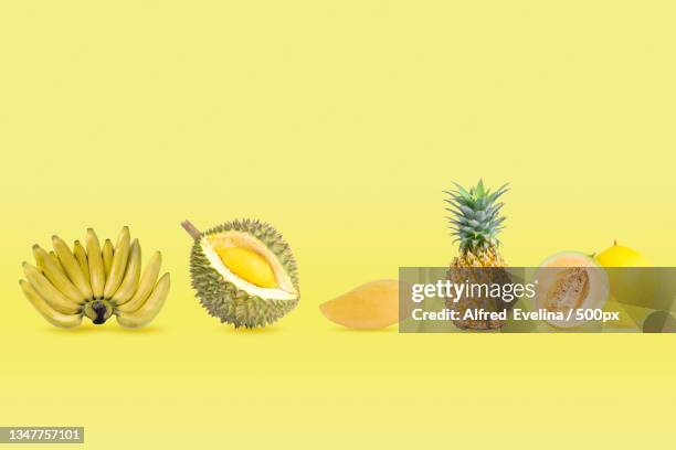 close-up of fruits against yellow background - durian stock pictures, royalty-free photos & images