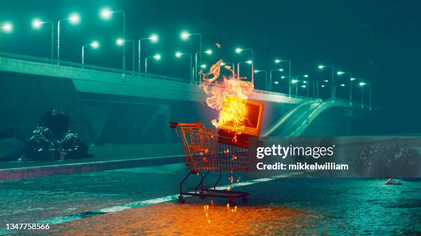 carrito de la compra con televisión vieja en llamas en una calle por la noche - insight tv fotografías e imágenes de stock