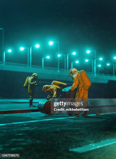 environmental protection agency at work at night moving large barrels - chemical warfare stockfoto's en -beelden