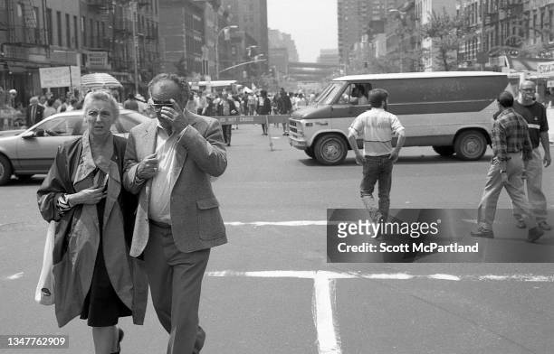 View of a couple walking together in the middle of 9th Avenue in Hell's Kitchen, New York, New York, May 20, 1989.