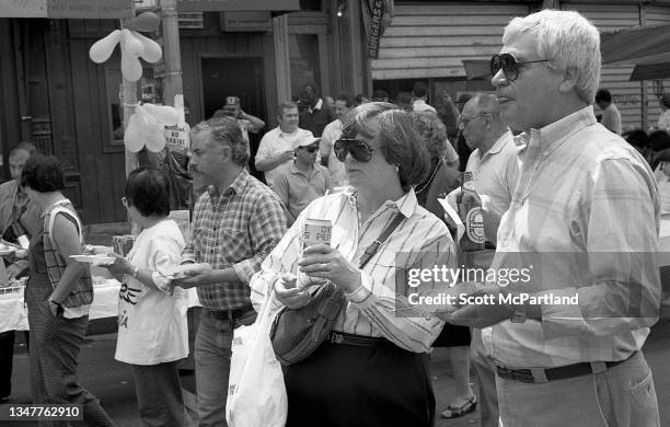 Pedestrians, most with food and drinks in their hands, gather on 9th Avenue in Hell's Kitchen during the International Food Festival, New York, New...