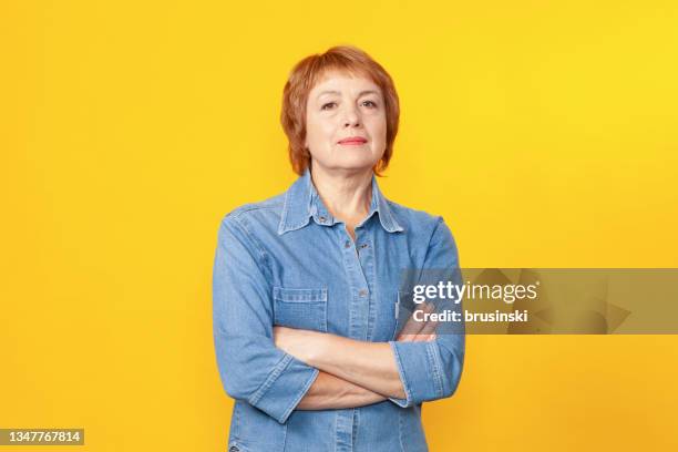 close up studio portrait of attractive 60 year old woman with short red hair - camisa de ganga imagens e fotografias de stock