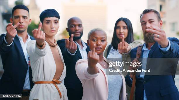 portrait of a group of young businesspeople showing the middle finger against an urban background - anti bullying stockfoto's en -beelden