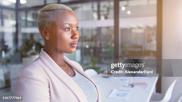 shot of a confident young businesswoman looking thoughtfully out of a window in a modern office - staring 個照片及圖片檔