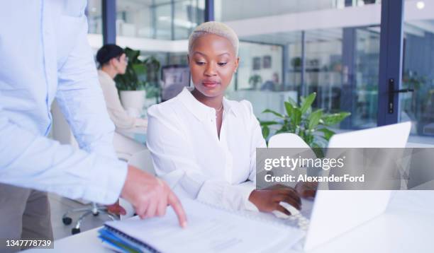 shot of a young businesswoman being handed a pile of paperwork in a modern office - delegating stockfoto's en -beelden