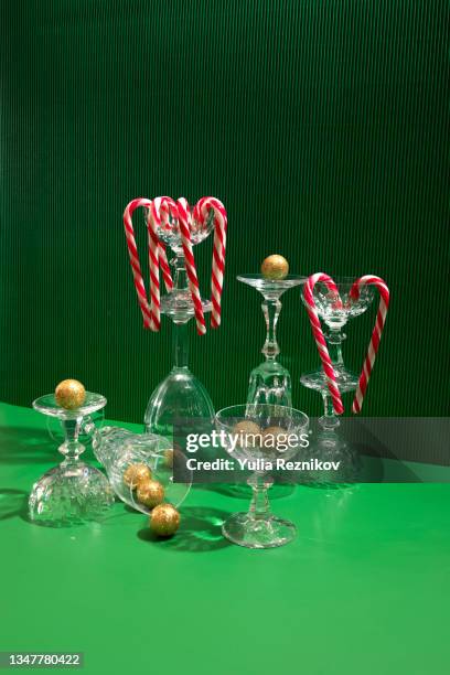 candy sticks, gold christmas balls and champagne glasses on green background - champagne pyramid stock pictures, royalty-free photos & images