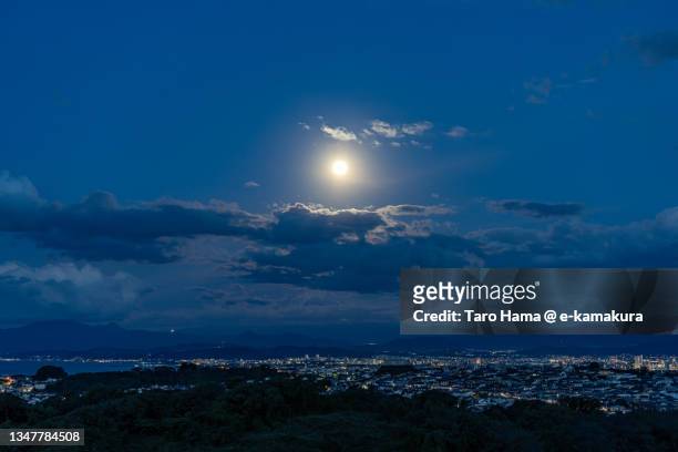 morning moon over snowcapped mt. fuji and the residential district by the sea in kanagawa of japan - evening ストックフォトと画像