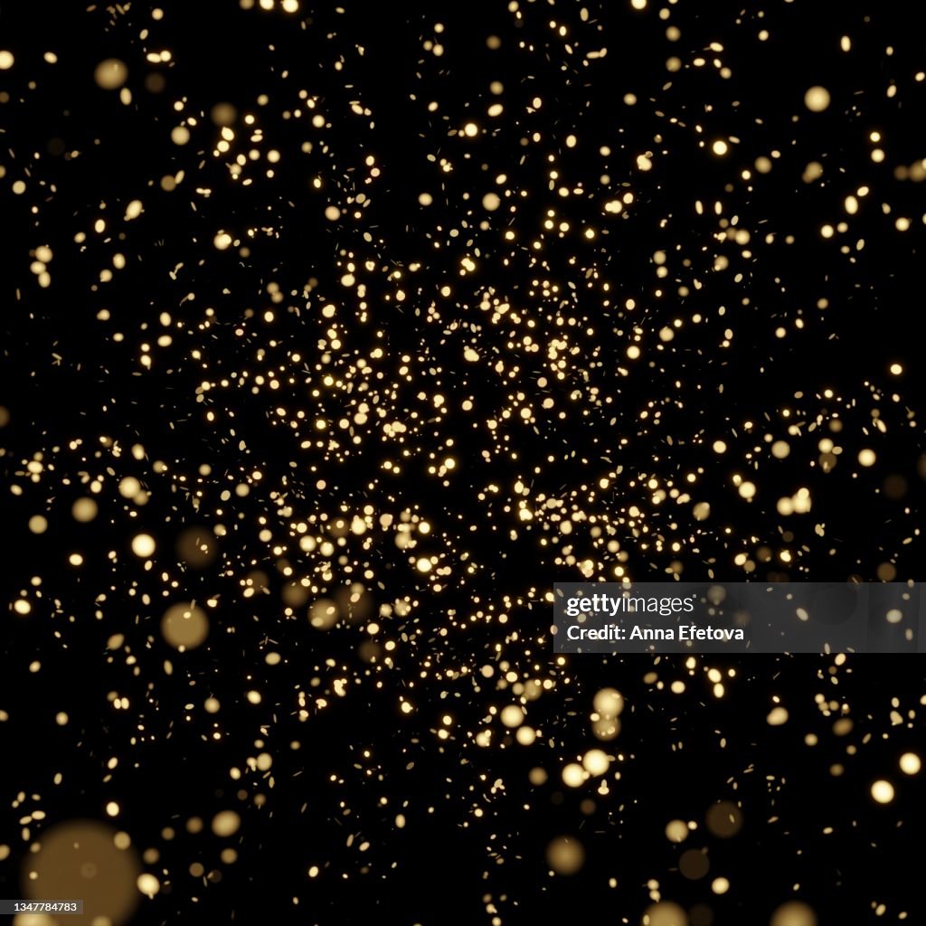 Splash of glittering golden confetti on black isolated background. Christmas and New Year concept in trendy festive golden color.